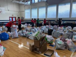 Gifts bagged up and ready for pick up in Gym with volunteers